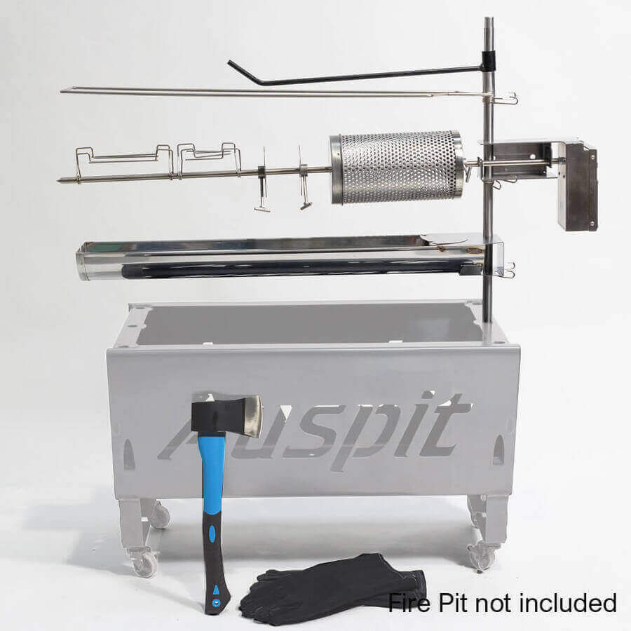 Auspit rotisserie kit setup with accessories including a stainless steel motor, rotisserie cage, skewer, drip tray, gloves, and hatchet. Fire pit not included.