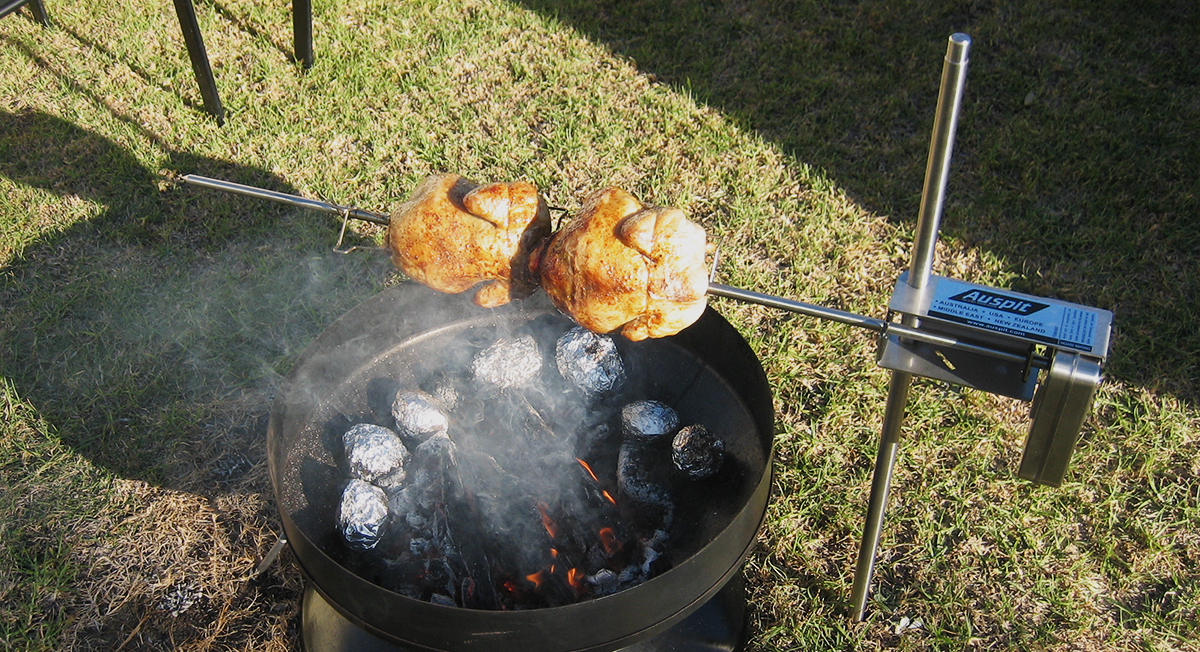 This image shows two whole chickens cooked in the Auspit spitmate