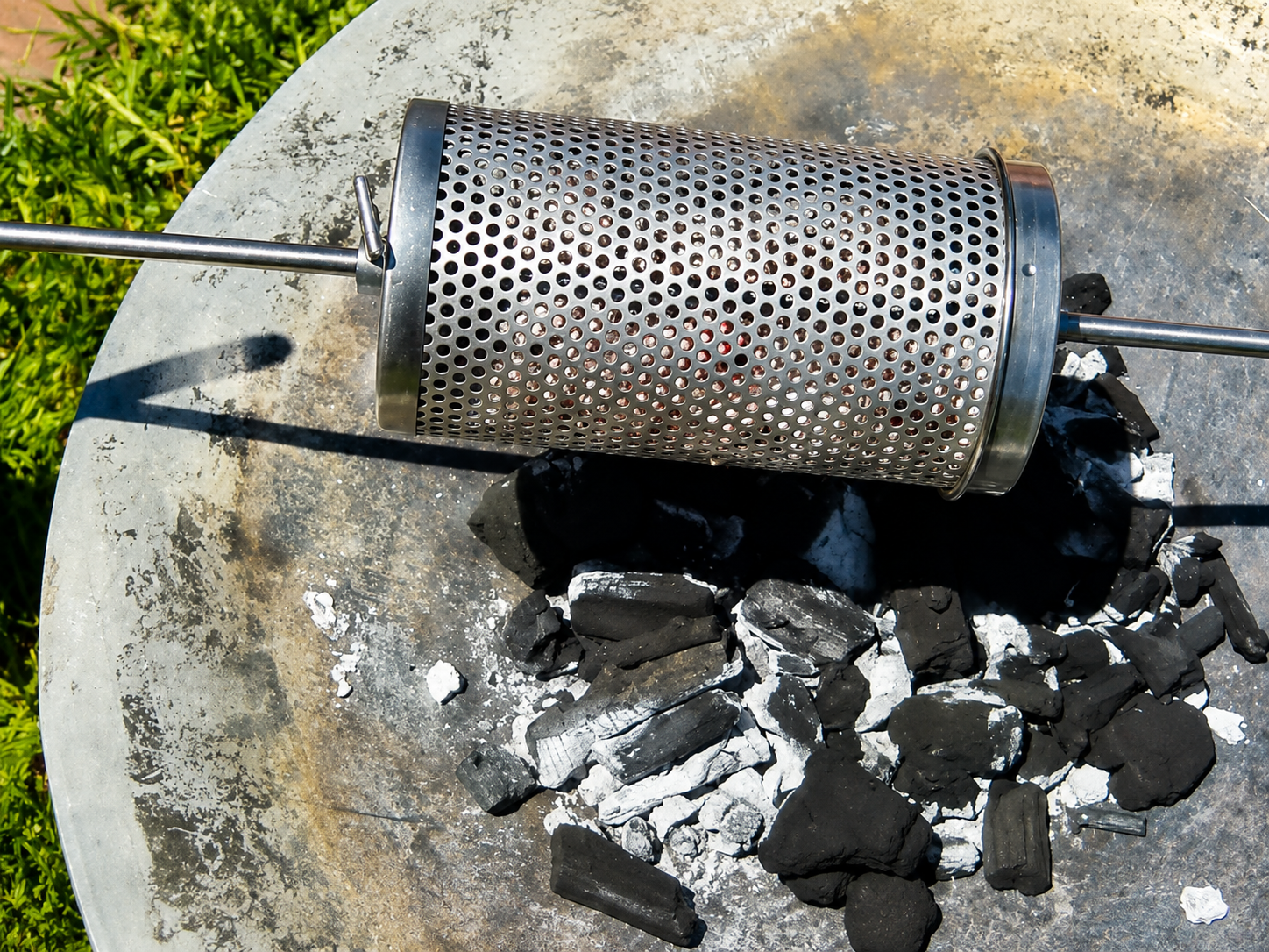 This image shows the chicken wings on the spit mate cooked over charcoal. This image shows the chicken wings on the spit mate cooked over charcoal.