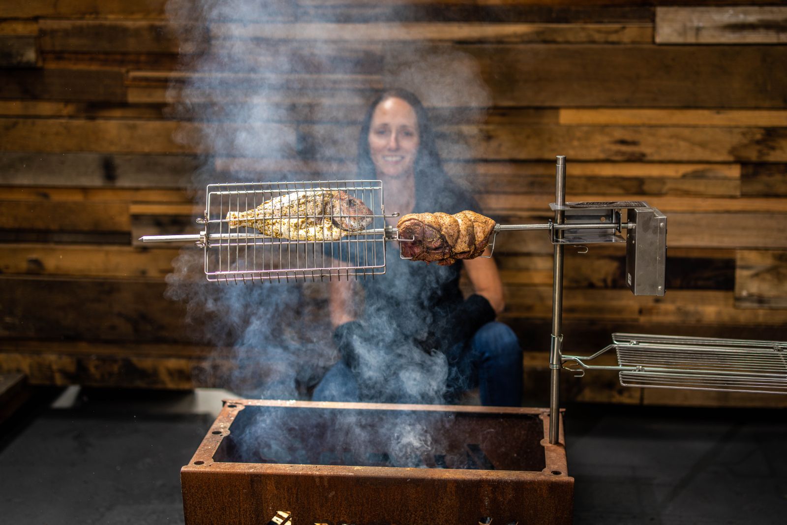 This image shows the Auspit Rotisserie Kit cooking fish and leg of lamb.