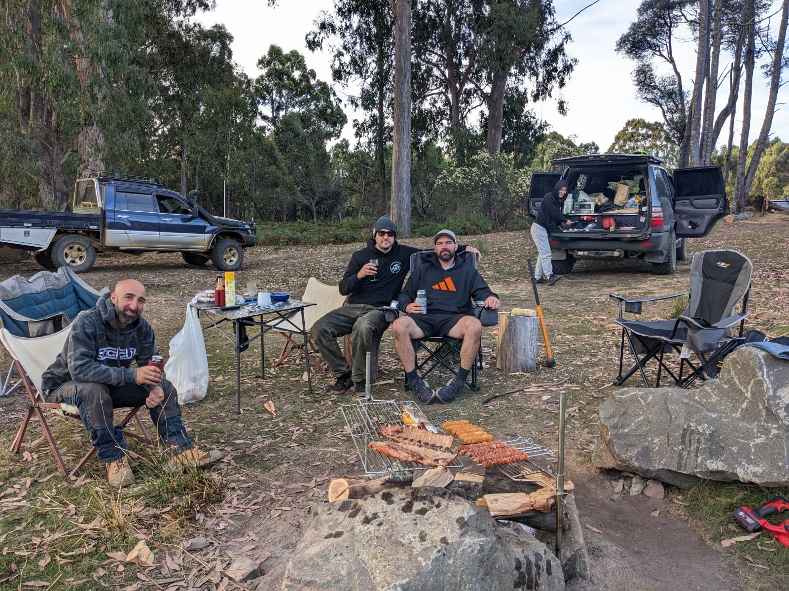 Campfire BBQ using an Auspit spit and stainless steel grill with mates in the Australian bush