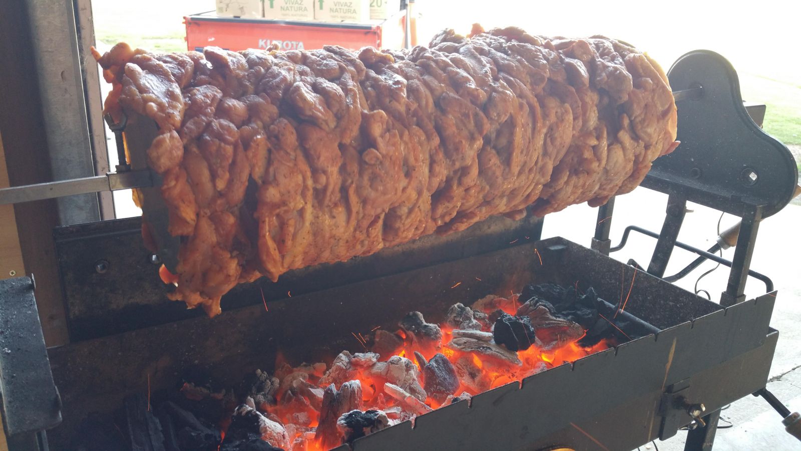 This image show a spit roaster cooking gyros above some hot mallee root lump charcoal