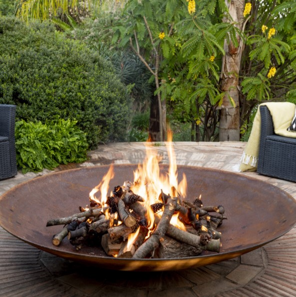 this is an image of a modern lowline round rustic firepit 800mm in the backyard
