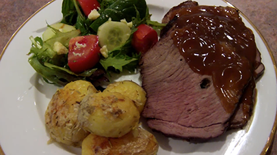 This image shows a cooked roast beef, potatoes and veggies served in a plate