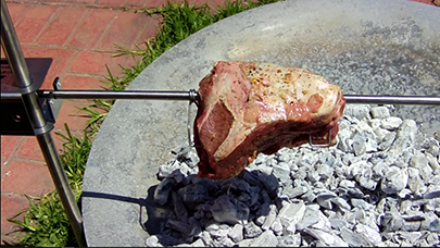 This image shows a beef placed on the Auspit Portable Spit Roaster