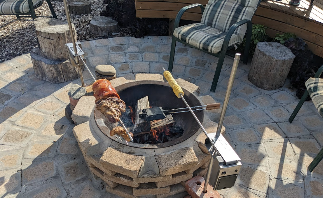Leg Of Lamb Roasting On Spit Over Outdoor Fire Pit