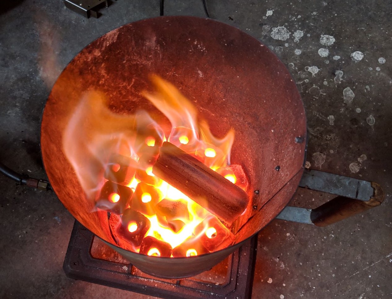 image show charcoal briquettes being lit in a chimney starter