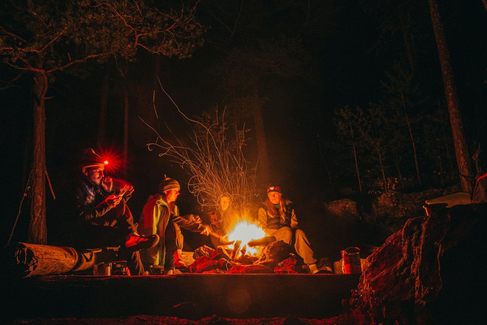 Campers sitting around a campfire at night sharing stories in the bush